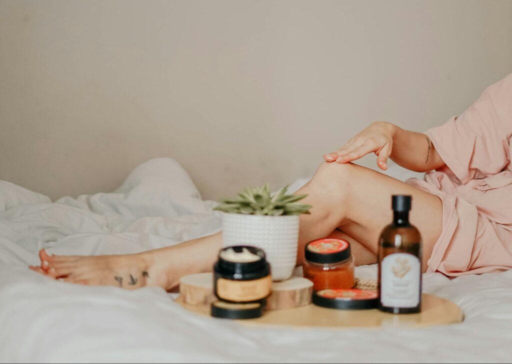 oman in a robe surrounded by self care products